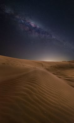 the night sky is filled with stars above sand dunes