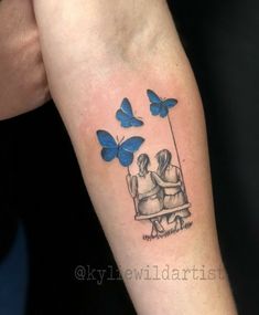 two people sitting on a bench with blue butterflies