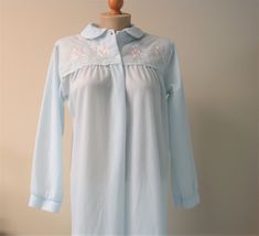 "Vintage Katz brushed fleece robe/nightgown in pale blue soft brushed lightweight fleece.  Fabric is a poly-nylon blend.  Front yoke has sweetly embroidered pink floral detail and satin edged round collar. Two button front and pullover entry.  This gown is in like new condition!  Made in USA. Perfect for a cozy evening at home. -  -  -  DETAILS & MEASUREMENTS -  -  -  Label/maker - Katz Size/fit - sm 8-10 Shoulder - 15\" Bust - 20\" Waist/hip - 25\" Length - back of neck to hem 53\" Condition - Blue Long Sleeve Nightgown For Lounging, Light Blue Long Sleeve Nightgown For Spring, Light Blue Long Sleeve Nightgown For Bedtime, Light Blue Long Sleeve Nightgown For Sleep, Light Blue Long Sleeve Nightgown, Blue Long Sleeve Hospital Nightgown, Long Sleeve Blue Nightgown For Hospital, Fleece Robe, Cozy Evening