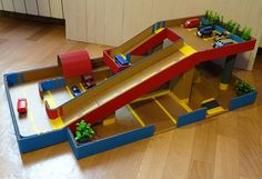 a toy train set with cars and ramps on the floor