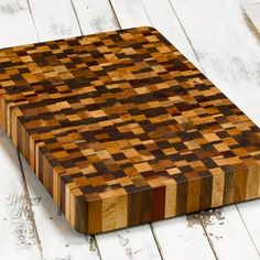 a wooden cutting board sitting on top of a white table