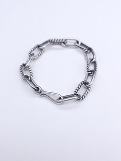 This chain bracelet is made in the style of our plain twist chain necklace. It has an alternating plain round wire link and twist wire link that is certainly going to enhance your style. The finish on the chain has an oxidized finish. It can be a high polished finished upon request. Each link is hand crafted and assembled. Sterling Silver Bracelet With Cable Chain Design, Classic Silver Cable Chain Bracelet, Silver Oval Link Chain Bracelet With Cable Detail, Silver Cable Chain Bracelet With Oval Links, Silver Cable Chain Sterling Silver Bracelet, Sterling Silver Cable Chain Bracelet In Silver, Sterling Silver Bracelet With Cable Chain In Silver, Silver Cable Chain Link Bracelet, Silver Sterling Chain Bracelet With Hooks And Links