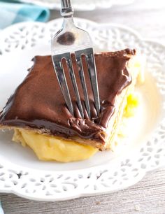 a piece of cake with chocolate frosting and a fork stuck in it on a white plate