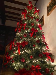 a decorated christmas tree with red bows and lights