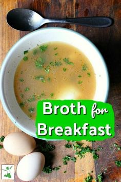 broth for breakfast in a bowl with eggs and parsley next to it on a wooden table