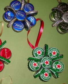 four beer bottle caps with ribbons attached to them on a green tableclothed surface