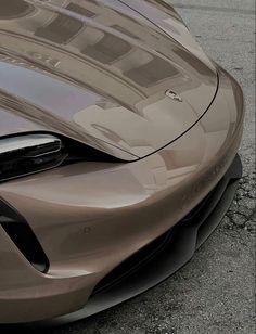 the front end of a brown sports car