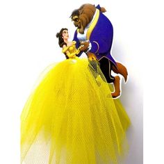 beauty and the beast figurine on top of a yellow dress