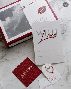 some cards and tags are laying on a marble counter top with the word love written on them