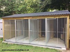 a metal fenced in dog kennel with sliding doors on the outside and inside