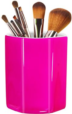 a pink cup filled with lots of makeup brushes