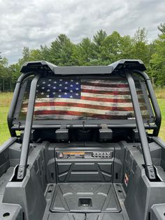 an american flag painted on the back of a truck's cargo compartment in a field