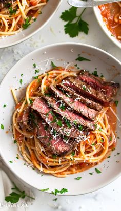 two white bowls filled with pasta and meat