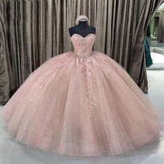 a pink ball gown on display in front of curtains