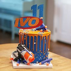 a birthday cake decorated with an orange and blue icing drips on top of it