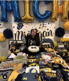 a woman sitting on a bed holding a cake in front of balloons and streamers