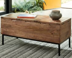 a coffee table with an open drawer on top and a vase sitting on the end