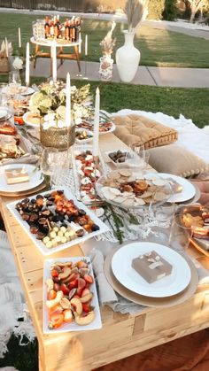 an outdoor picnic is set up on the grass with food and drinks laid out in front of it