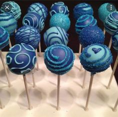 there are many blue cake pops on the table