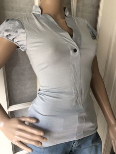 "This super cute BCBGeneration top is in good condition. Outdoor photos are most accurate for color which is a pale silvery blue. This is an XS so do check measurements. There is a bit of stretch with 4% spandex. Lying flat measurements  Bust 14 1/2\" Waist 11 1/2\" Total length 24\"" Elegant Fitted V-neck T-shirt, Elegant Gray Crew Neck Top, Gray Stretch Short Sleeve Shirt, Light Blue Fitted Shirt For Spring, Fitted Light Blue Shirt For Spring, Gray Stretch Summer Blouse, Stretch Gray Summer Blouse, Light Blue Fitted Crew Neck Tops, Stretch Summer Blouse In Gray