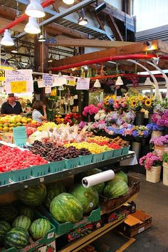 an outdoor market with lots of fruits and vegetables