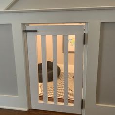 an open door to a dog house with a black cat in the room behind it