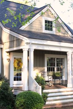 a small house with porch and steps leading to the front door