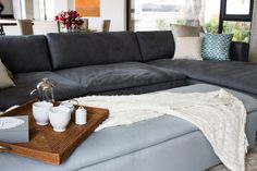 a living room with a gray couch and coffee table in front of a large window