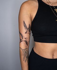 a woman with a bird tattoo on her left arm and right arm behind her back