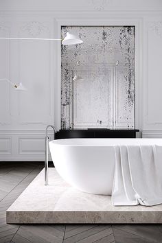 a white bath tub sitting on top of a tiled floor