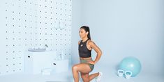 a woman squatting on a stool in front of a white wall with polka dots