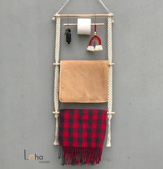 a towel hanging on a wall next to a toilet paper roll and some other items