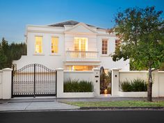 a large white house with an iron gate