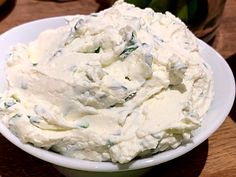 a white bowl filled with mashed potatoes on top of a wooden table