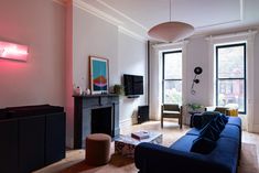 a living room filled with furniture and a flat screen tv mounted on the wall next to a fire place