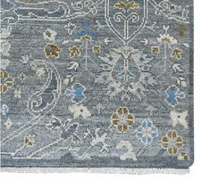 an area rug with blue and yellow flowers on the bottom, in front of a white background