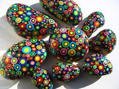 some colorful rocks are sitting on a white surface and have circles painted on them with different colors