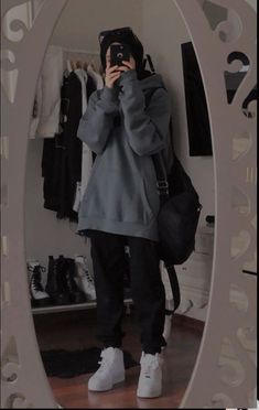 a person taking a selfie in front of a mirror with shoes on the floor