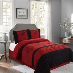 a bed with red and black comforters in a room