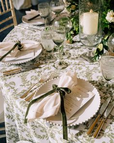 the table is set with place settings and napkins, silverware, and flowers