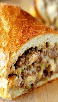 a close up of a sandwich on a wooden table with other food items in the background