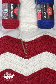 three balls of yarn are sitting next to each other on a white and red blanket