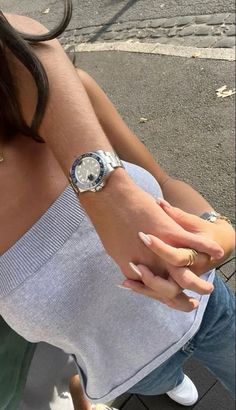 a woman sitting on the ground holding onto her watch