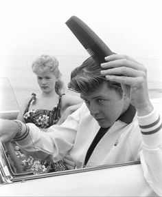 a man and woman sitting in a car with their hair dryer over their head