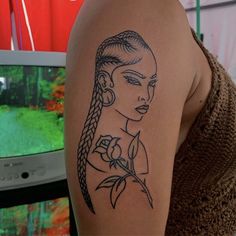 a woman's arm with a tattoo on it and a tv in the background