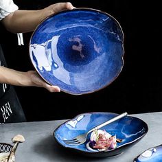 a person holding a blue plate with food on it