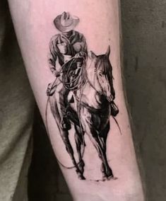 a black and white photo of a man riding a horse with a lasso on his arm