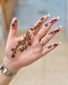 a woman's hand with hendix on it and flowers painted on the palm