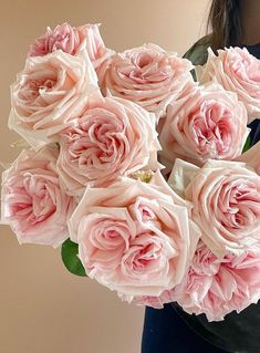 a woman holding a bouquet of pink roses