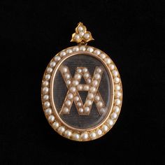 This large Victorian locket features the initials "VA" (or perhaps "AV") are rendered in gold and pearls atop a piece of black grosgrain fabric. The reverse side features a lovely portrait miniature of a young woman with a blue ribbon in her hair. Gold Lockets, Gold And Pearls, Victorian Locket, Gold Locket, Black Ribbon, Blue Ribbon, Young Woman, Locket, Her Hair